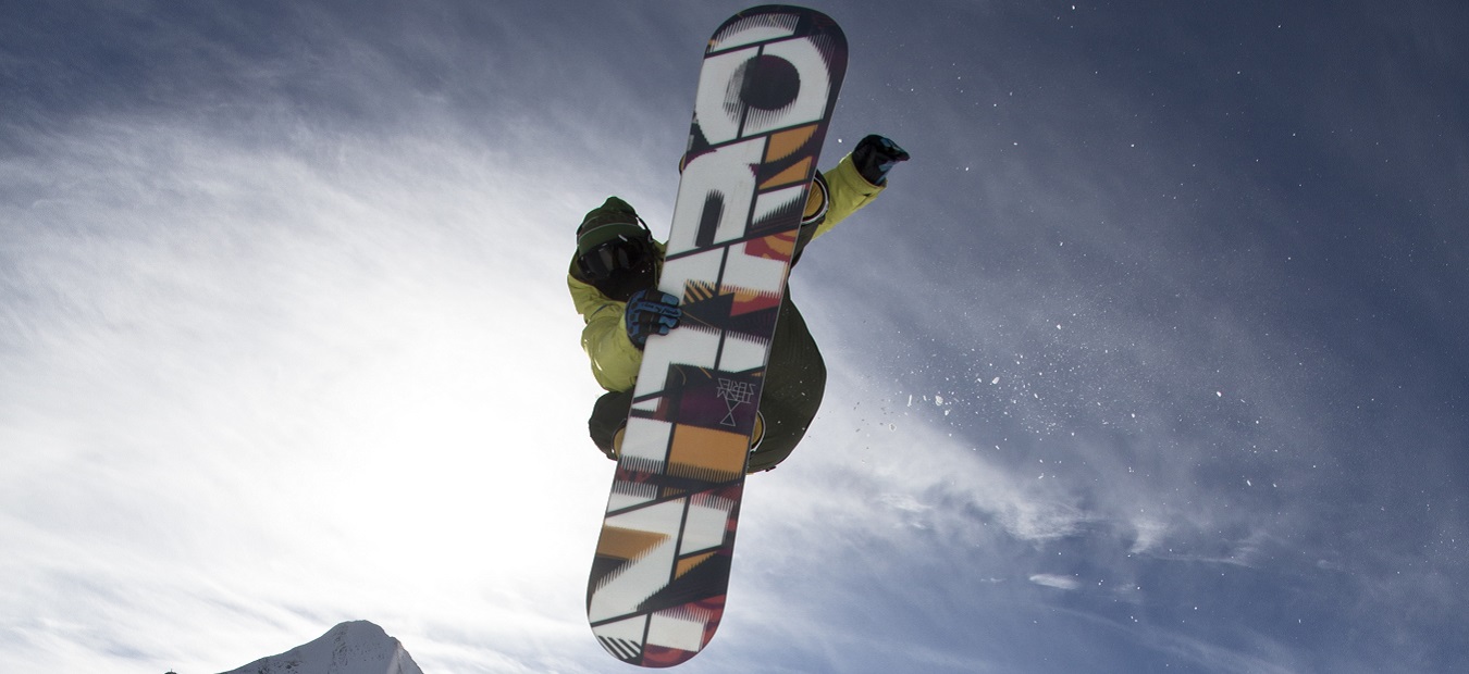 Snowboarder jumping and looking into the camera