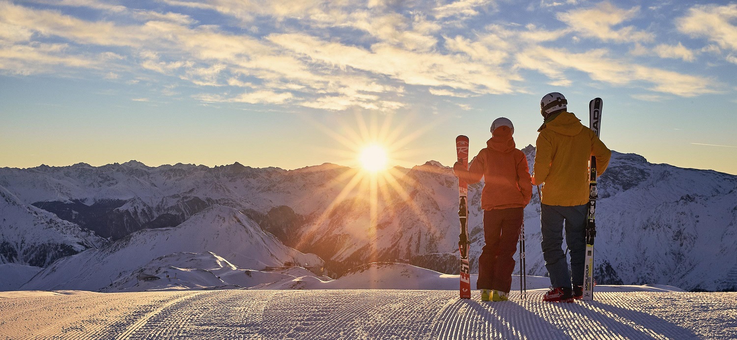 Skiers watching a sunrise