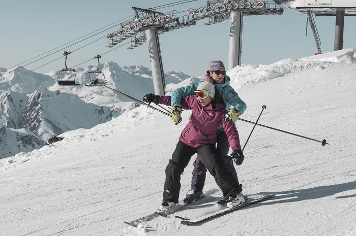 Book a group ski holiday in Courchevel with Skiweekends Couple skiing on the slopes